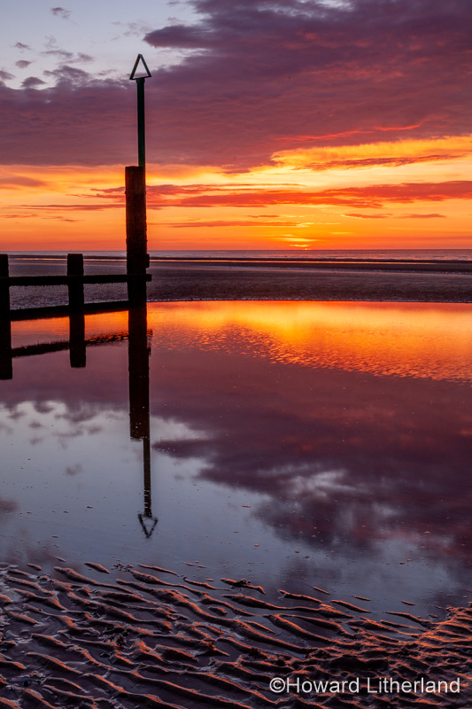 Sunset over Rhyl beach at low tide on the North Wales coast