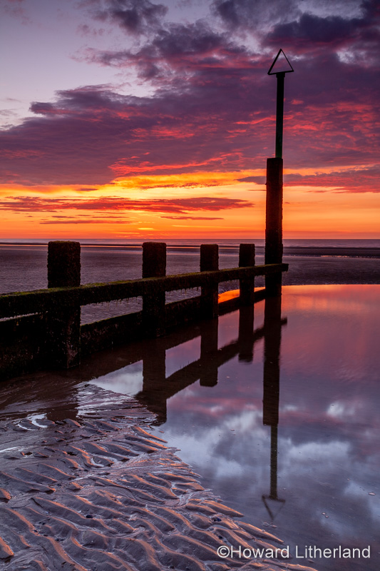Sunset over Rhyl beach at low tide on the North Wales coast
