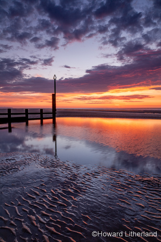 Sunset over Rhyl beach at low tide on the North Wales coast