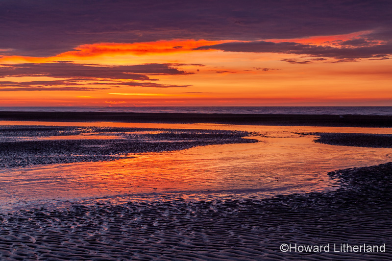 Sunset over Rhyl beach at low tide on the North Wales coast