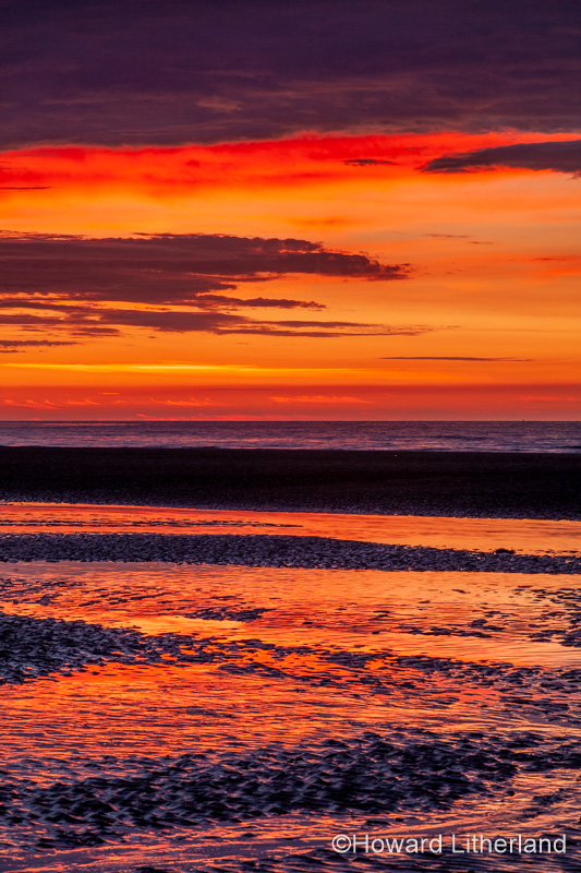 Sunset over Rhyl beach at low tide on the North Wales coast