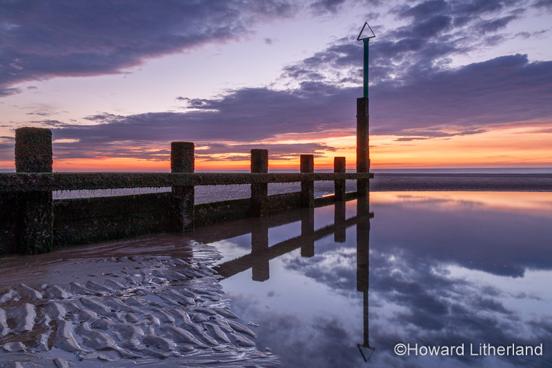 Sunset over Rhyl beach at low tide on the North Wales coast