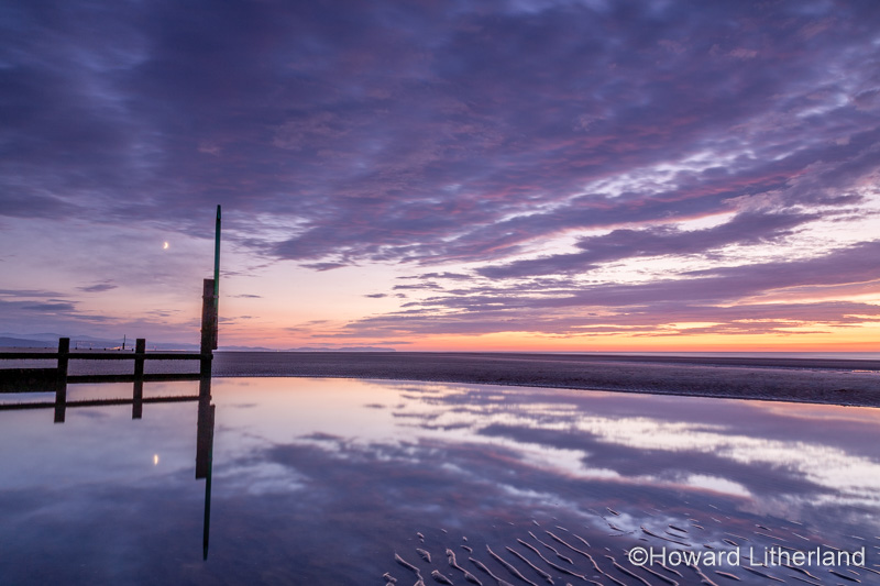 Sunset over Rhyl beach at low tide on the North Wales coast