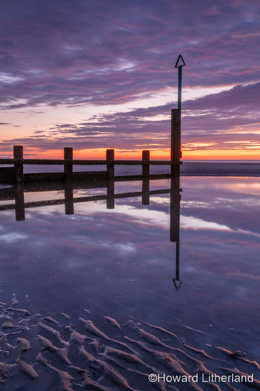 Sunset over Rhyl beach at low tide on the North Wales coast