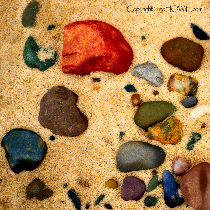 Colourful stones and sand on the beach at Conwy Morfa, North Wales