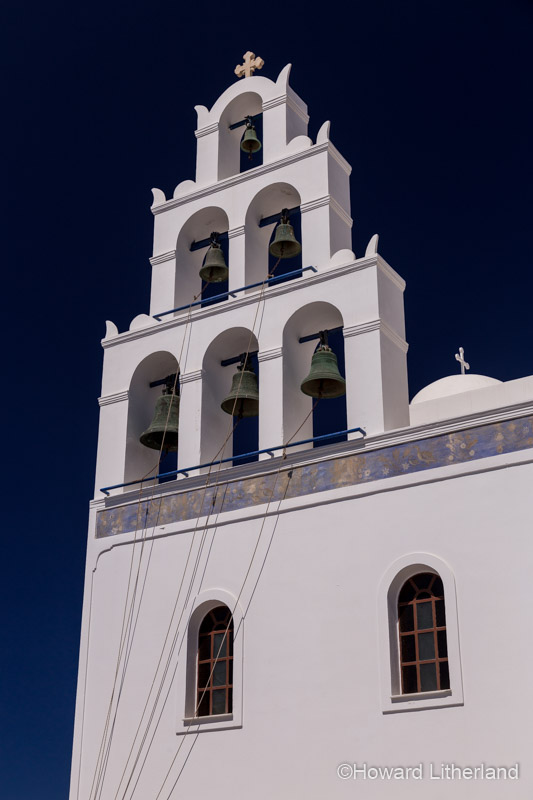 White painted church bell tower and bells at Oia on the island of Santorini