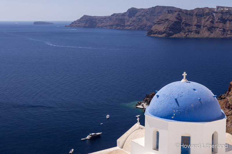 Church with blue dome overlooking the Aegean sea at Oia on the island of Santorini