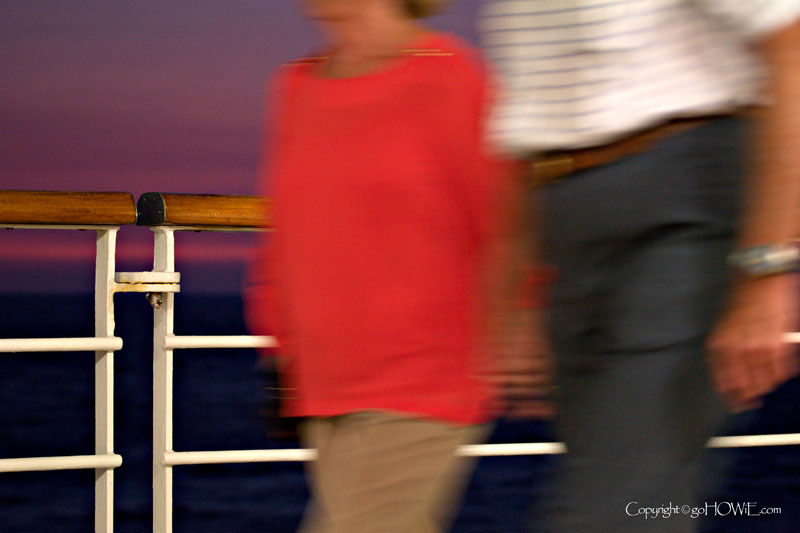 Two blurred passengers walking along the promenade deck on the P&O liner Arcadia