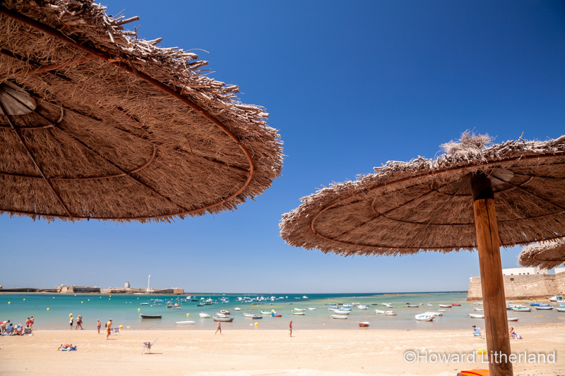 Palm leaf parasols on the beach at Cadiz, Spain