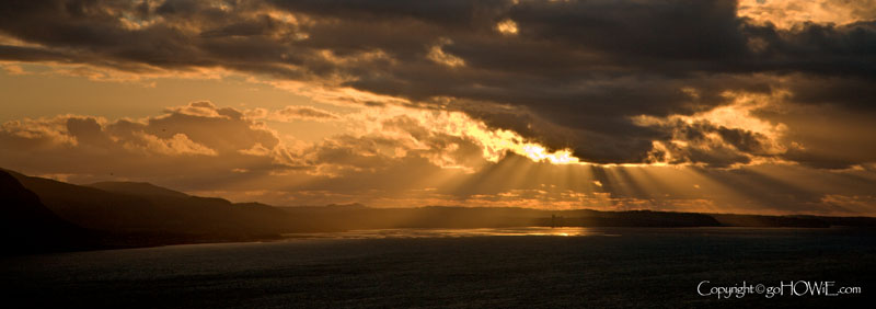 Photo of sun rays shining through heavy cloud onto the sea, North Wales coast, Penmaenmawr, Llanfairfechan, viewed from the Great Orme