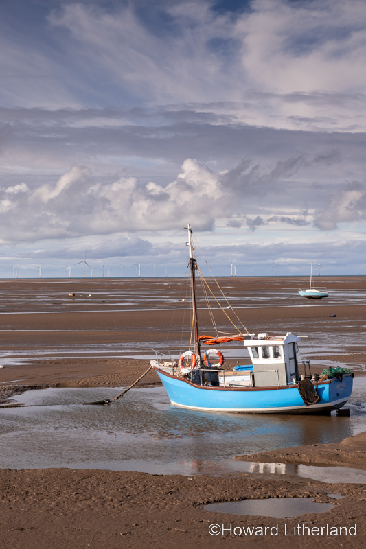 Fishing boat on the beach at low tide at Meols on the Wirral, England