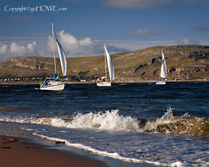 Three yachts sailing up the Conwy estuary, North Wales